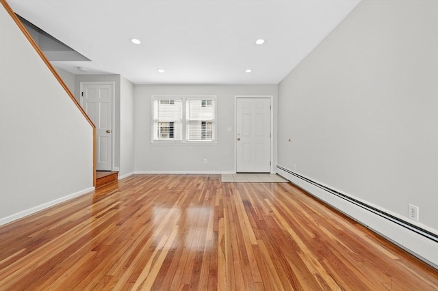 foyer entrance with baseboard heating and light hardwood / wood-style floors