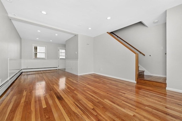 unfurnished living room with light wood-type flooring and a baseboard radiator