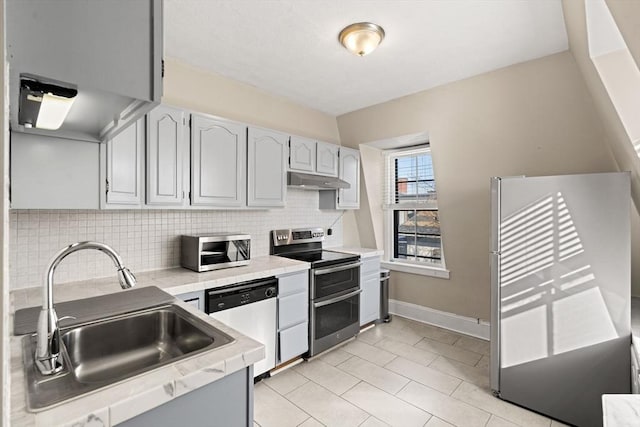 kitchen featuring sink, light tile patterned floors, stainless steel appliances, and tasteful backsplash