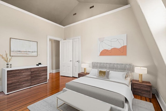 bedroom with hardwood / wood-style floors and high vaulted ceiling