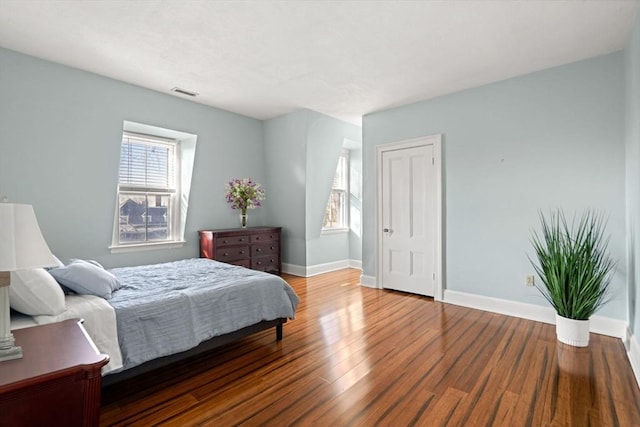 bedroom featuring wood-type flooring and multiple windows