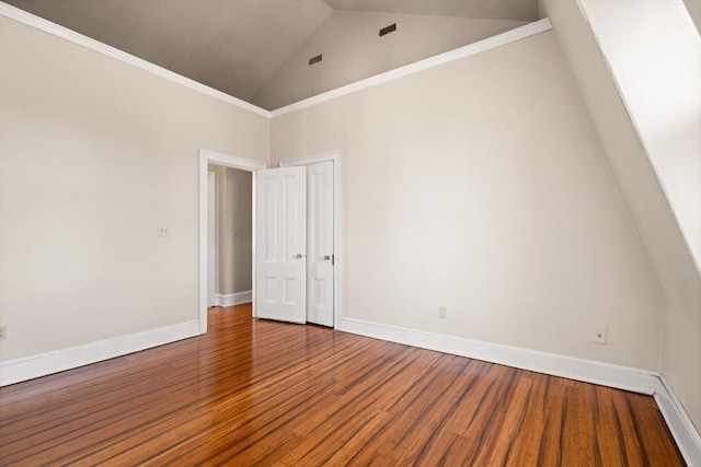 empty room with hardwood / wood-style flooring and high vaulted ceiling