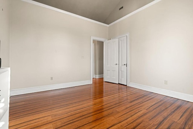 spare room featuring high vaulted ceiling and wood-type flooring