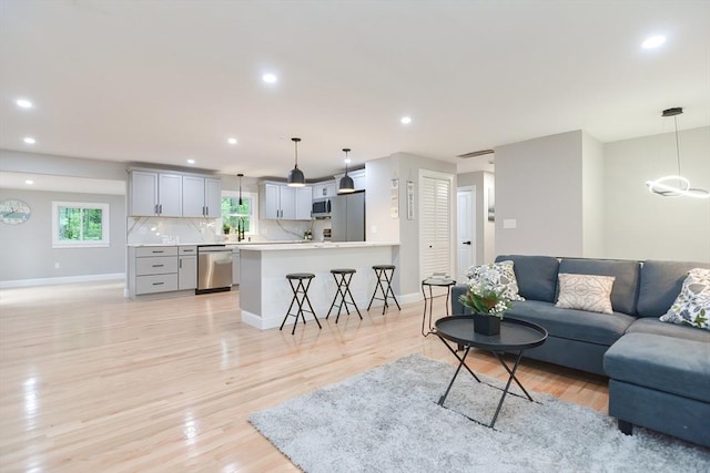 living room with light hardwood / wood-style flooring and sink