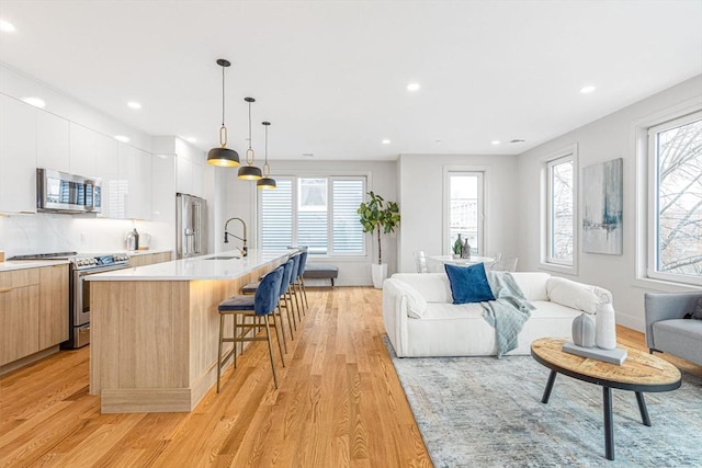 living room featuring light wood-type flooring and sink