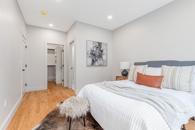 bedroom featuring a closet, a spacious closet, and light hardwood / wood-style flooring