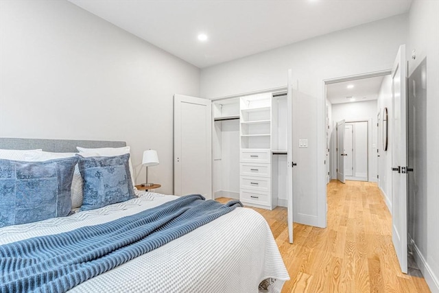 bedroom with light hardwood / wood-style floors and a closet