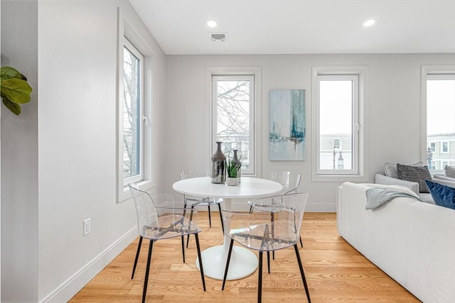 dining area with a wealth of natural light and light hardwood / wood-style flooring