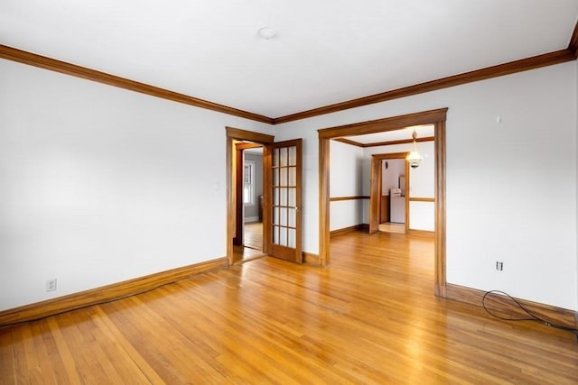 spare room featuring crown molding and light hardwood / wood-style floors