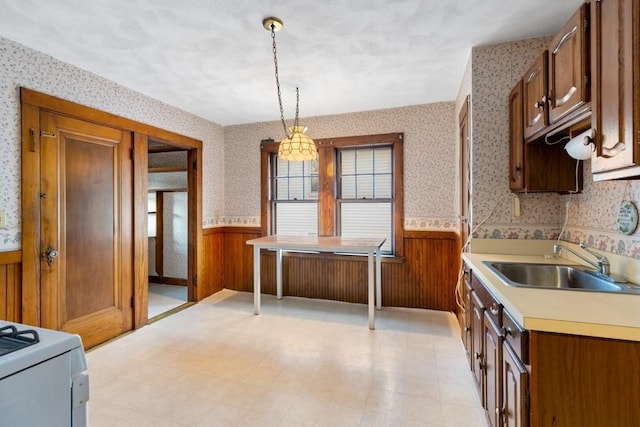 kitchen featuring sink, decorative light fixtures, and range