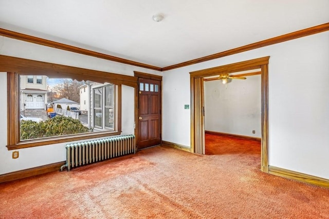 carpeted empty room featuring crown molding and radiator