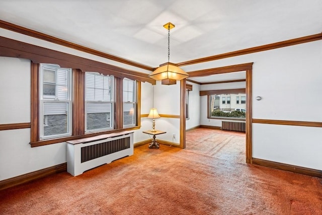 spare room featuring radiator, crown molding, and carpet flooring