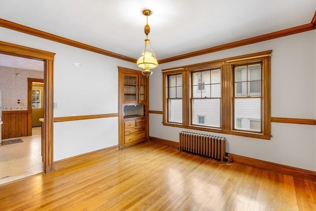 unfurnished room with ornamental molding, radiator, and light hardwood / wood-style floors