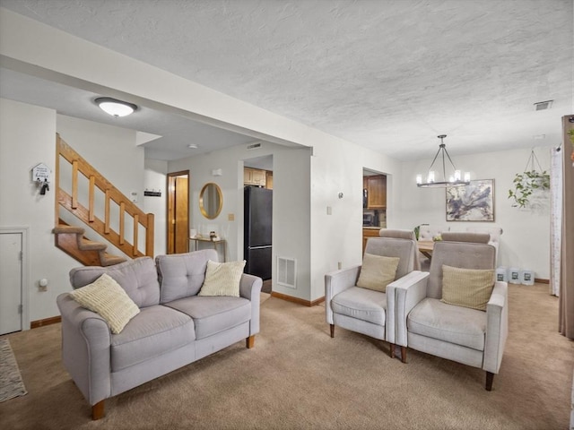 49 Meadow Pond Dr Unit I, Leominster, MA 01453 - living area featuring carpet floors, a chandelier, a textured ceiling, and stairs