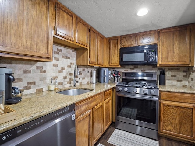 49 Meadow Pond Dr Unit I, Leominster, MA 01453 - kitchen featuring appliances with stainless steel finishes, tasteful backsplash, brown cabinets, light stone countertops, and a textured ceiling