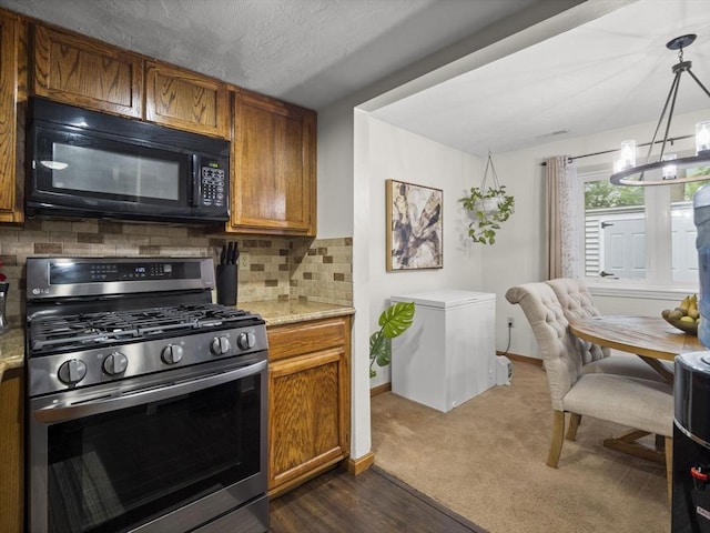 49 Meadow Pond Dr Unit I, Leominster, MA 01453 - kitchen with black microwave, gas stove, a chandelier, brown cabinets, and backsplash