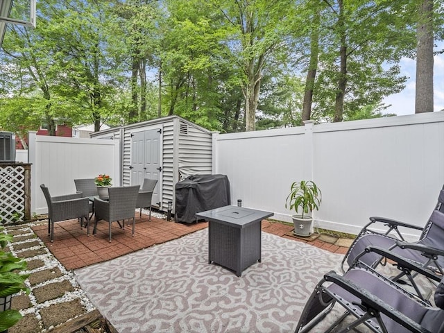 49 Meadow Pond Dr Unit I, Leominster, MA 01453 - fenced backyard with a grill, a storage unit, outdoor dining area, and a patio