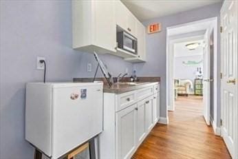 laundry area with a sink and wood finished floors