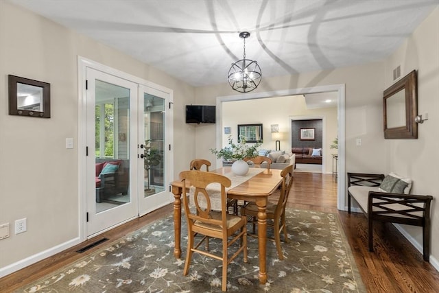 27 Bowker Dr, Sudbury, MA 01776 - dining room with french doors, wood finished floors, a chandelier, and baseboards