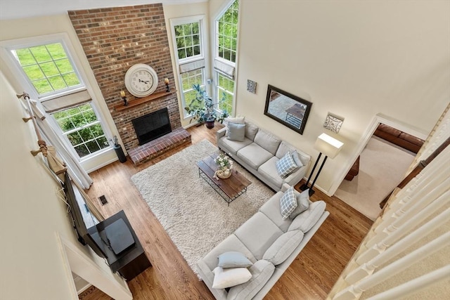 27 Bowker Dr, Sudbury, MA 01776 - living room featuring wood finished floors, a brick fireplace, baseboards, and a towering ceiling