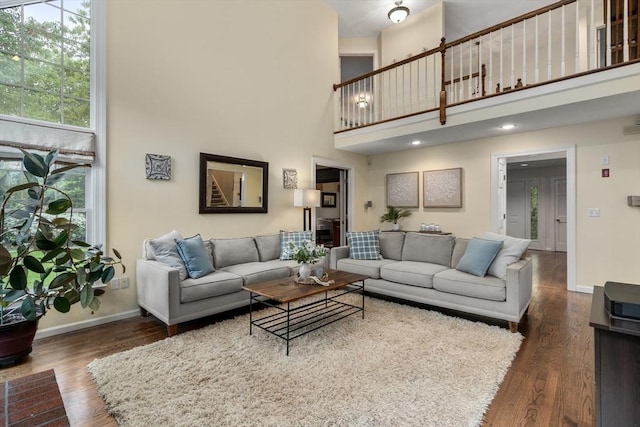 27 Bowker Dr, Sudbury, MA 01776 - living area with a high ceiling, dark wood-style flooring, and baseboards
