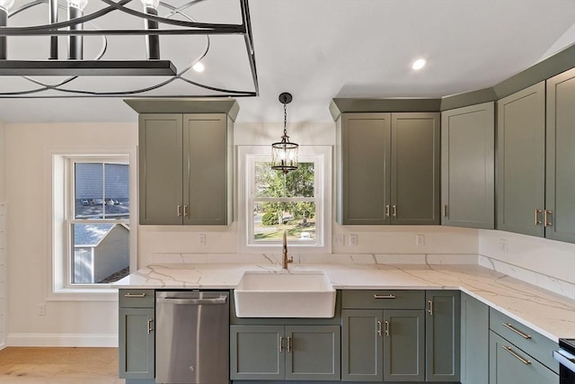 kitchen featuring hanging light fixtures, a sink, stainless steel appliances, baseboards, and light stone countertops