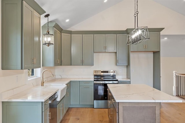 kitchen with appliances with stainless steel finishes, a chandelier, lofted ceiling, and a sink