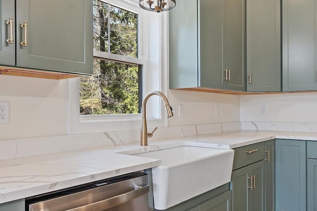 kitchen featuring a wealth of natural light, stainless steel dishwasher, light stone counters, and a sink