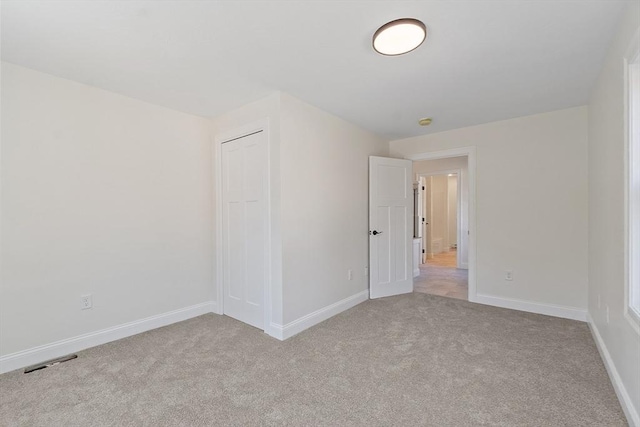 unfurnished room featuring light carpet, baseboards, and visible vents