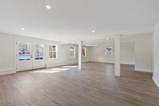 basement featuring recessed lighting, baseboards, a healthy amount of sunlight, and wood finished floors