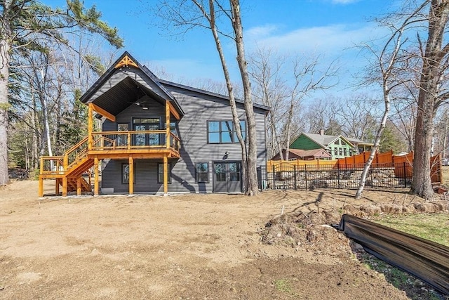 back of property featuring stairway, a deck, and fence