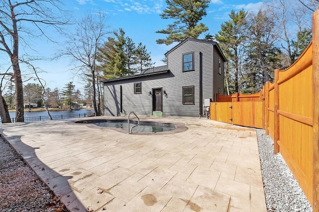 rear view of property with a patio, a fenced in pool, a fenced backyard, and a gate