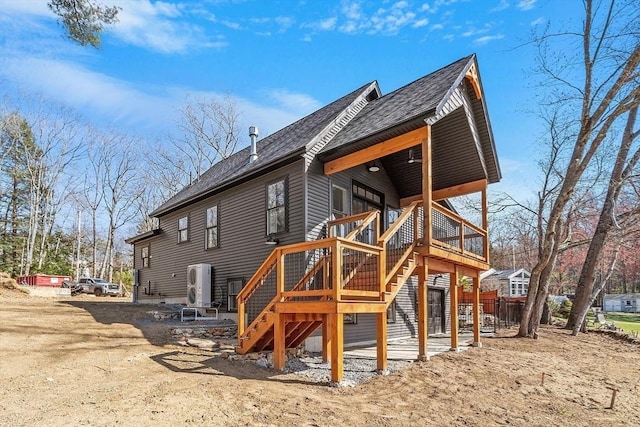 rear view of house with roof with shingles