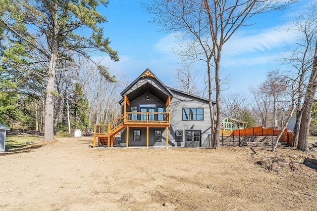back of house with fence, a wooden deck, and stairs