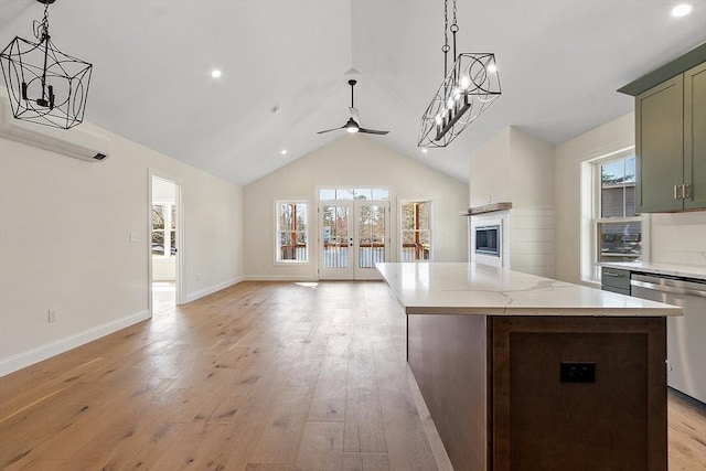 kitchen featuring stainless steel dishwasher, ceiling fan with notable chandelier, a wall mounted air conditioner, and open floor plan