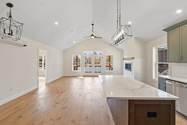 kitchen featuring a ceiling fan, stainless steel dishwasher, a glass covered fireplace, open floor plan, and a kitchen island