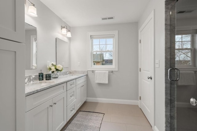 bathroom with tile patterned flooring, a shower with door, and vanity