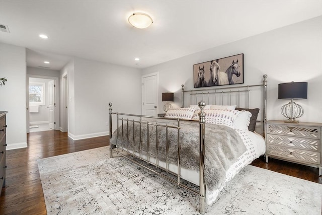 bedroom with dark hardwood / wood-style flooring and ensuite bath