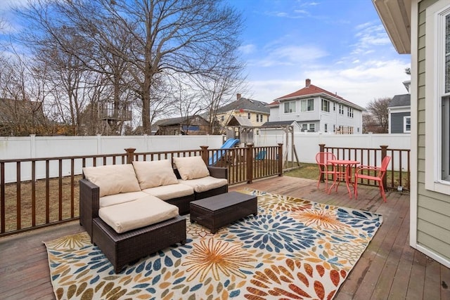 wooden terrace with a playground and outdoor lounge area