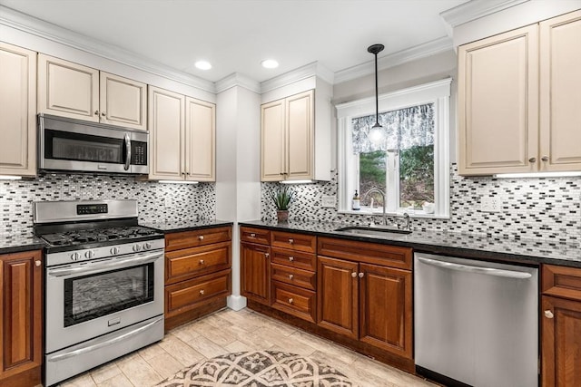 kitchen with crown molding, tasteful backsplash, appliances with stainless steel finishes, a sink, and decorative light fixtures