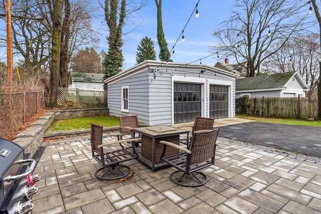 view of patio / terrace with a fenced backyard, a grill, an outbuilding, and a detached garage