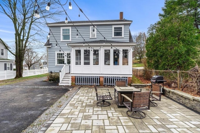 back of house with a patio area, entry steps, fence, and a chimney
