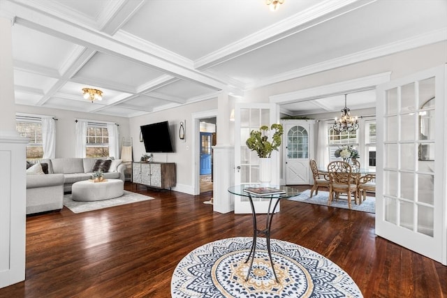 living room with beamed ceiling, ornamental molding, coffered ceiling, a notable chandelier, and hardwood / wood-style flooring