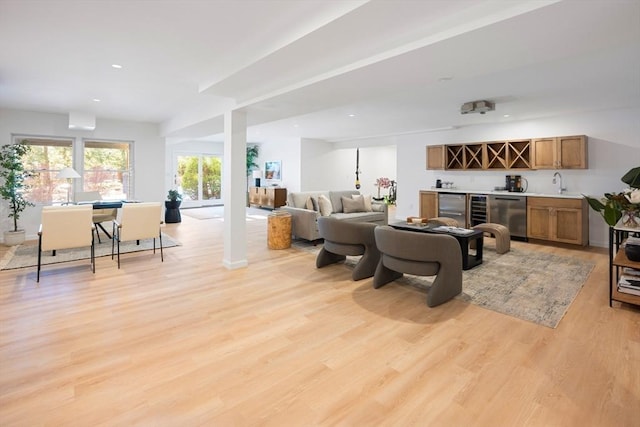 living room featuring indoor wet bar and light hardwood / wood-style flooring