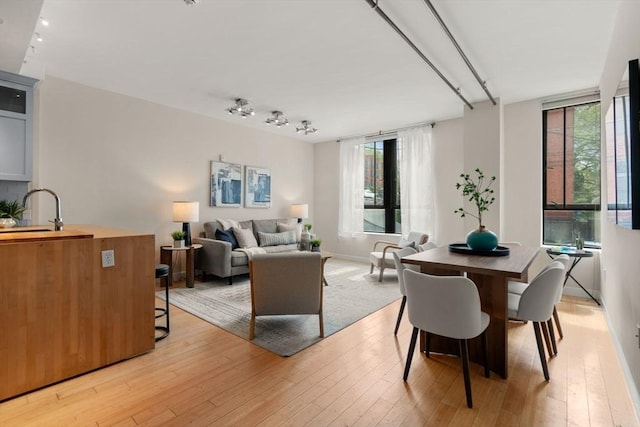 dining area featuring light wood finished floors, plenty of natural light, and baseboards