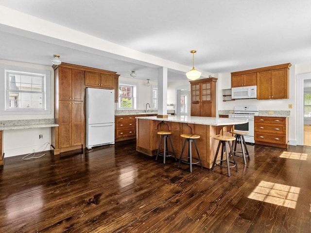 14 Parkman St, Westborough, MA 01581 - kitchen featuring white appliances, brown cabinetry, dark wood-type flooring, and plenty of natural light