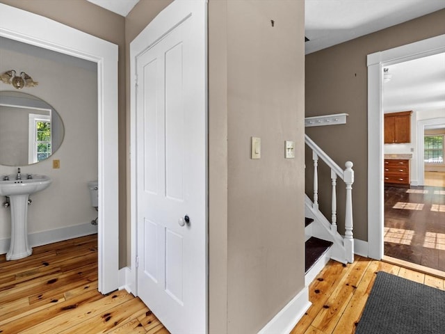 14 Parkman St, Westborough, MA 01581 - corridor with light wood-type flooring, baseboards, stairway, and a sink