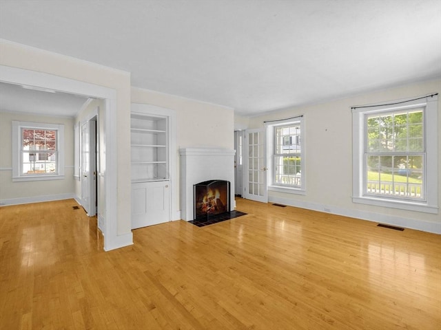 14 Parkman St, Westborough, MA 01581 - unfurnished living room with baseboards, light wood finished floors, a fireplace with flush hearth, and healthy amount of natural light