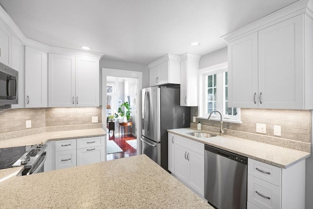 kitchen featuring appliances with stainless steel finishes, sink, white cabinets, and backsplash