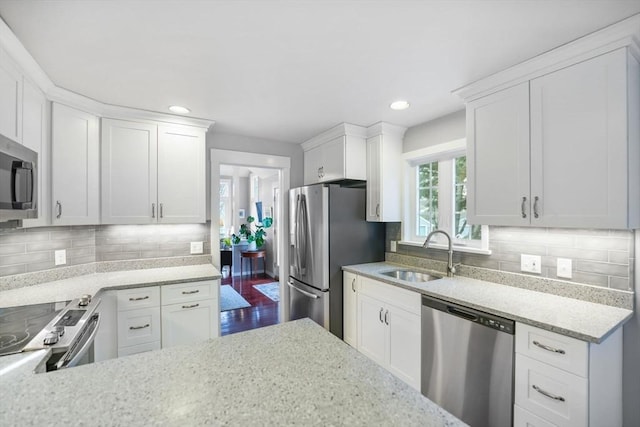 kitchen with appliances with stainless steel finishes, sink, and white cabinets